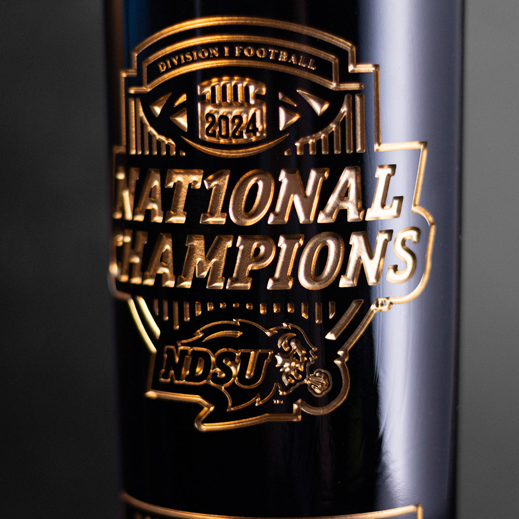 Close up of gold etched wine bottle with Division 1 Football 2024 National Champions and North Dakota State University Bisons logo