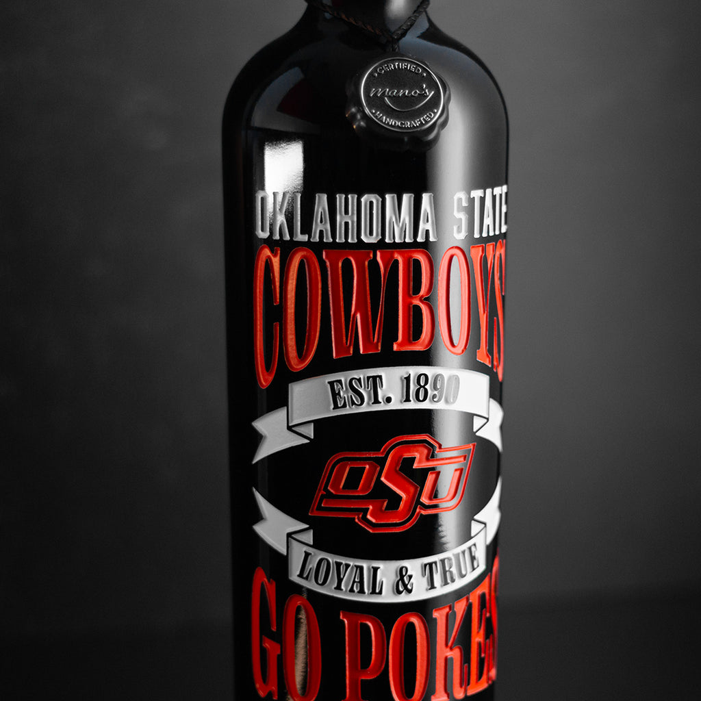 A bottle of Oklahoma State University Cowboys wine etched with Oklahoma State Cowboys, GO POKES, established 1890, OSU logo, and Loyal & True