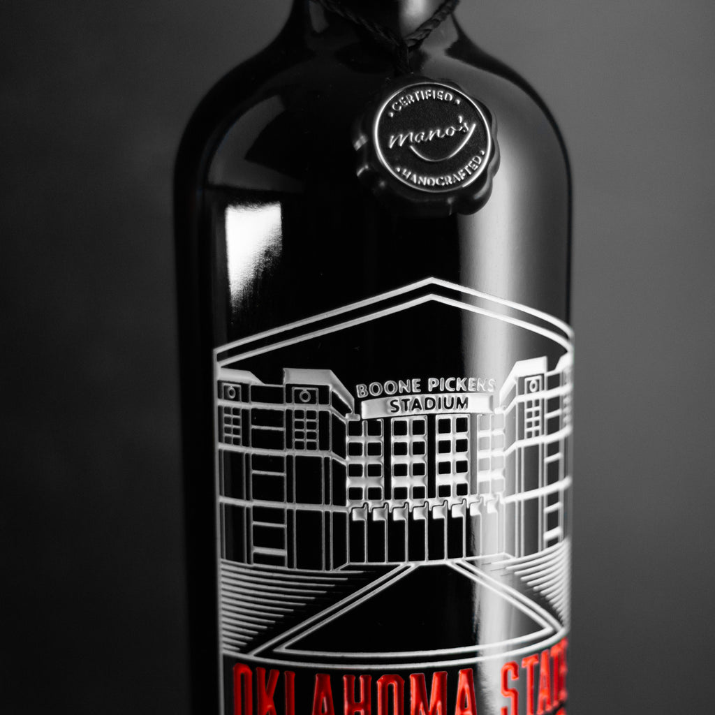 Close up view of Mano's Wine Oklahoma State University Boone Pickens Stadium etched on wine bottle