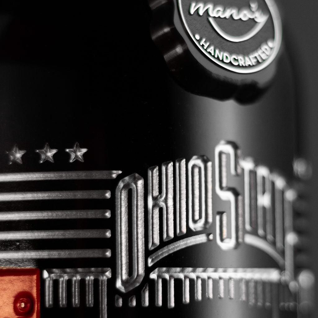 Close up of Mano's Wine emblem and Ohio State text and iconography etched on wine bottle