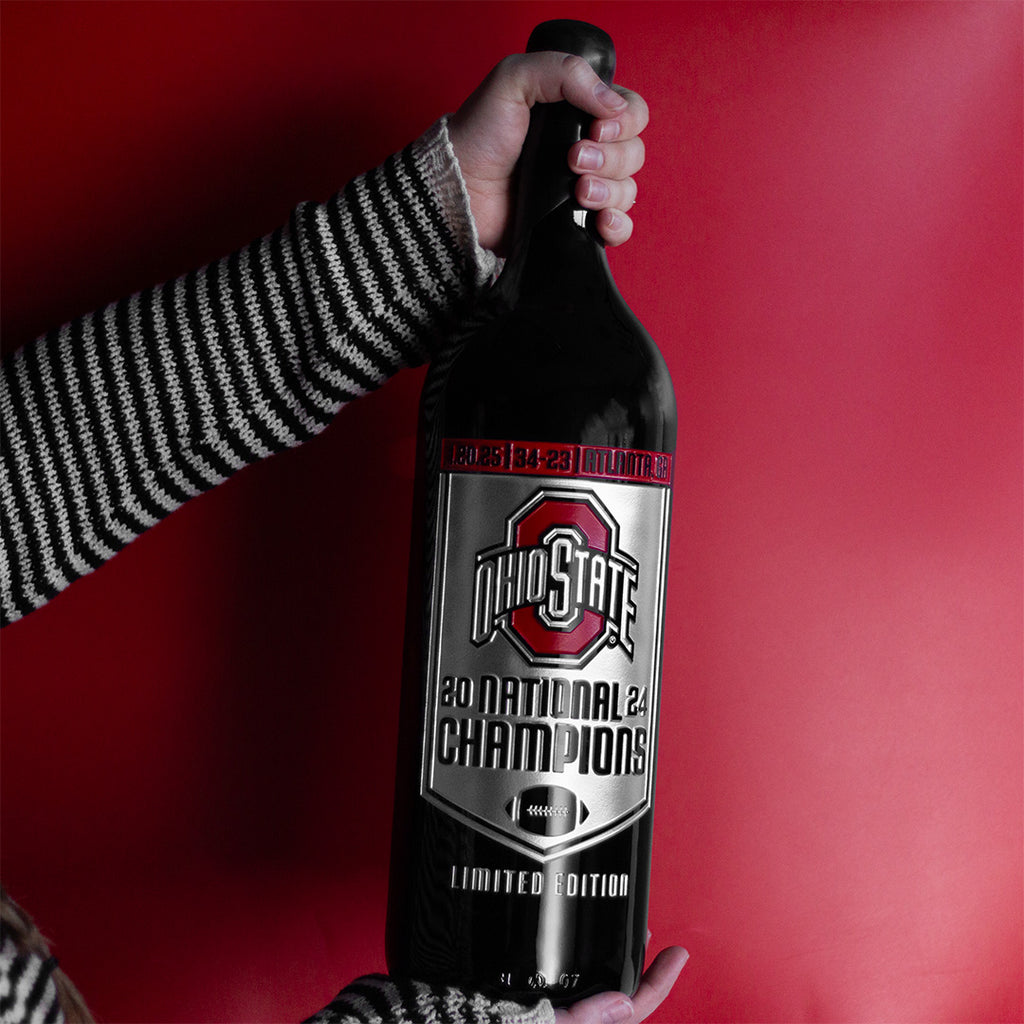 Fan holding limited edition Ohio State University 2024 National Champions 3L etched wine bottle from Mano's Wine