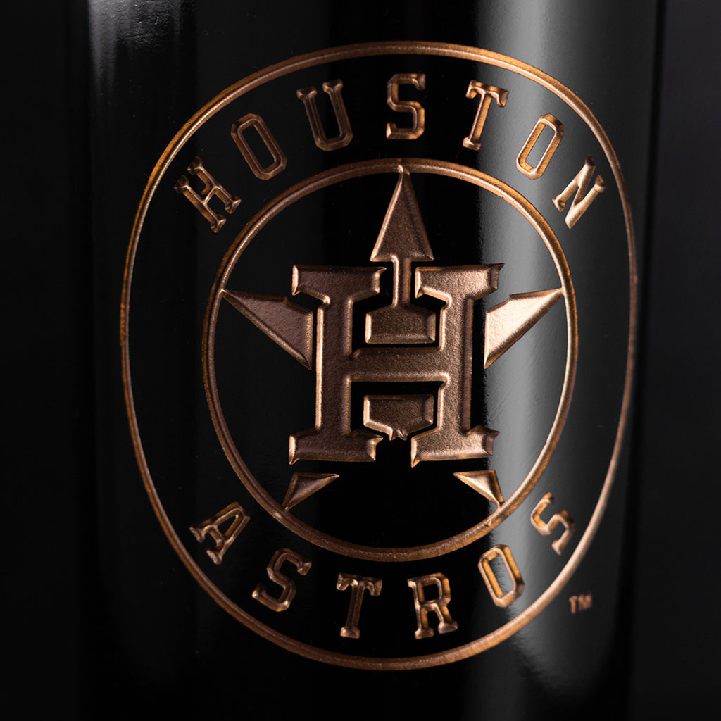 Close up image of Houston Astros etched in gold on a Mano's Wine bottle