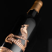 Close up of Mano's Wine bottle dipped in gold wax and etched with gold St. Louis Cardinals team logo