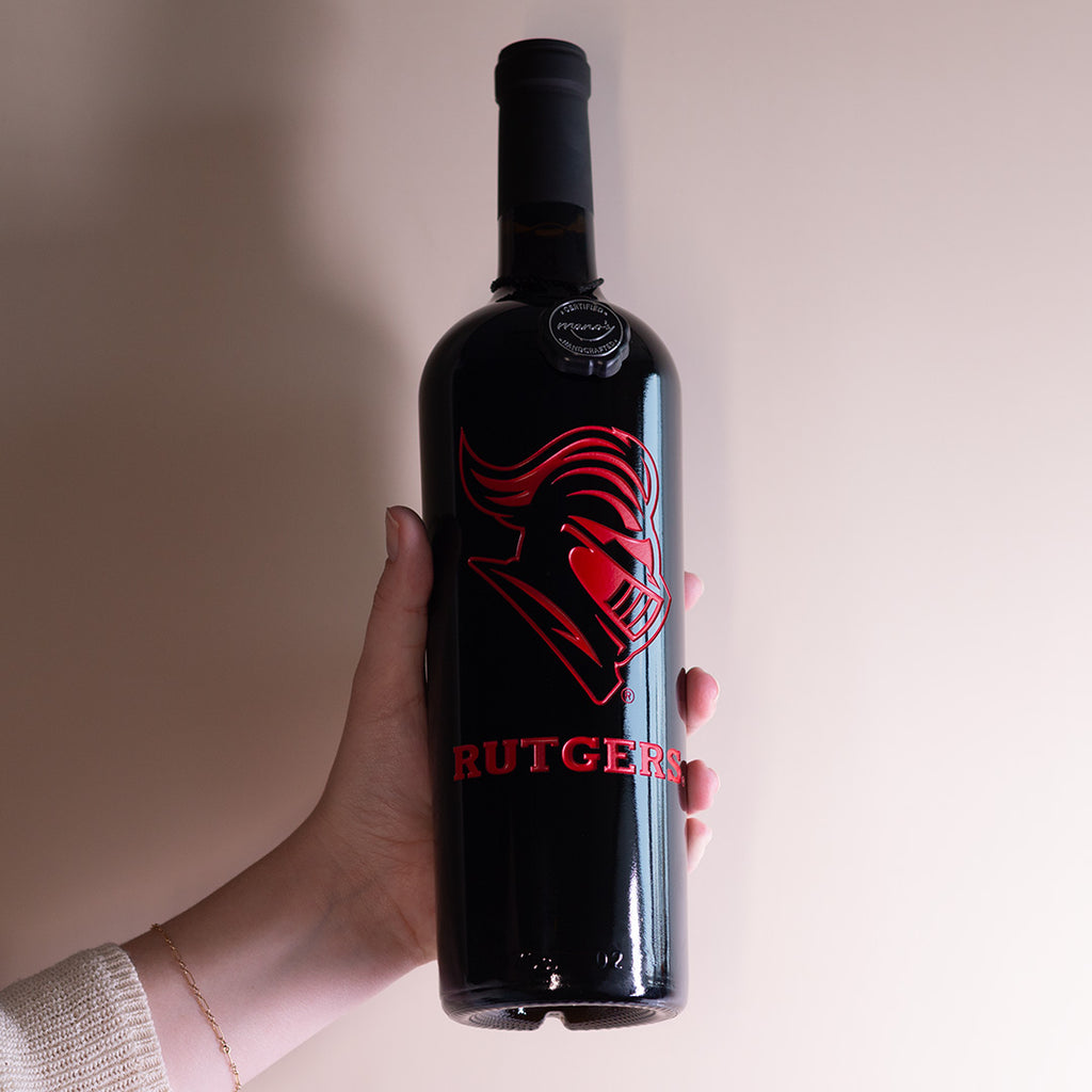 Hand holding up Rutgers University Scarlet Knight Etched Wine bottle from Mano's Wine