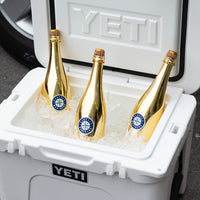 Three metallic silver Mano's Wine bottles of Seattle Mariners bubbly wines in a YETI cooler