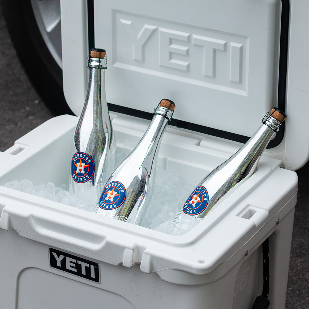 Three metallic silver Mano's Wine bottles of Houston Astros bubbly wines in a YETI cooler