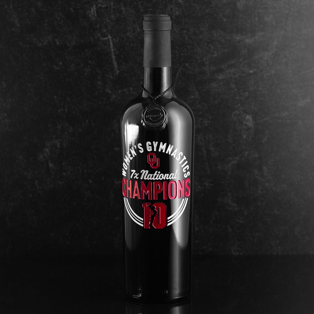 Mano's Wine bottle with OU Oklahoma University logo with text: "Women's Gymnastics 7x National Champions"