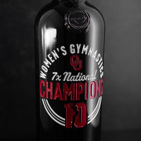 University of Oklahoma Women's Gymnastics 7x National Champions with cheerleader on the wine bottle