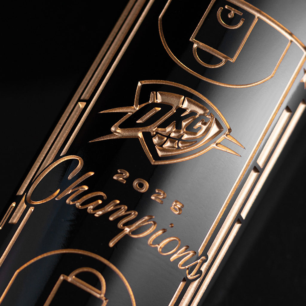 Close-up of a trophy with OKC Thunder logo, basketball court and 2025 Champions etched on Mano's Wine bottle