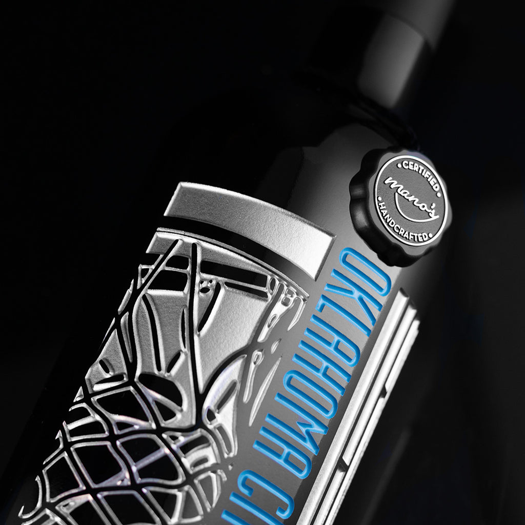 Close up of OKC Thunder etched cabernet sauvignon wine bottle with silver and OKC Thunder blue colors