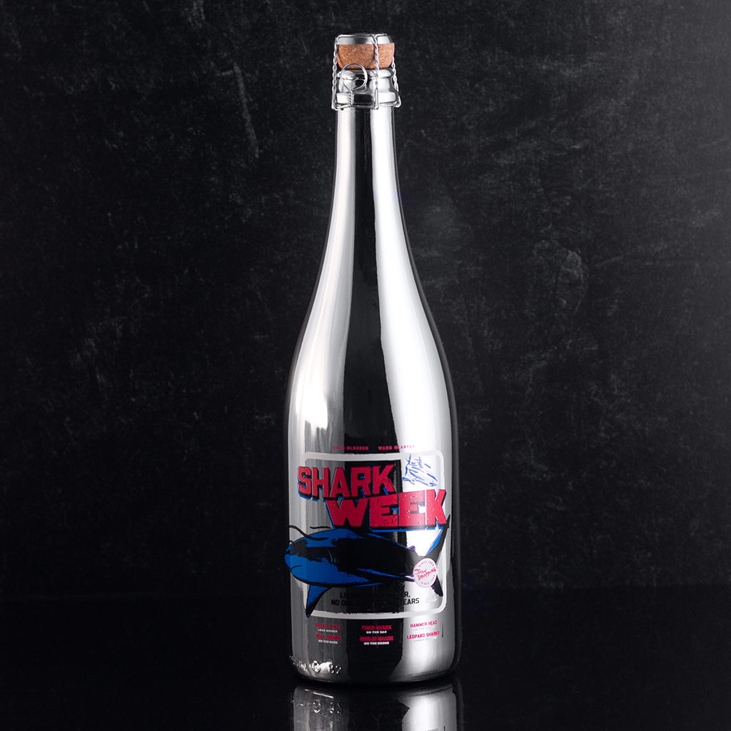 Mano's Wine silver bottle with Shark Week design on the bottle with a black background
