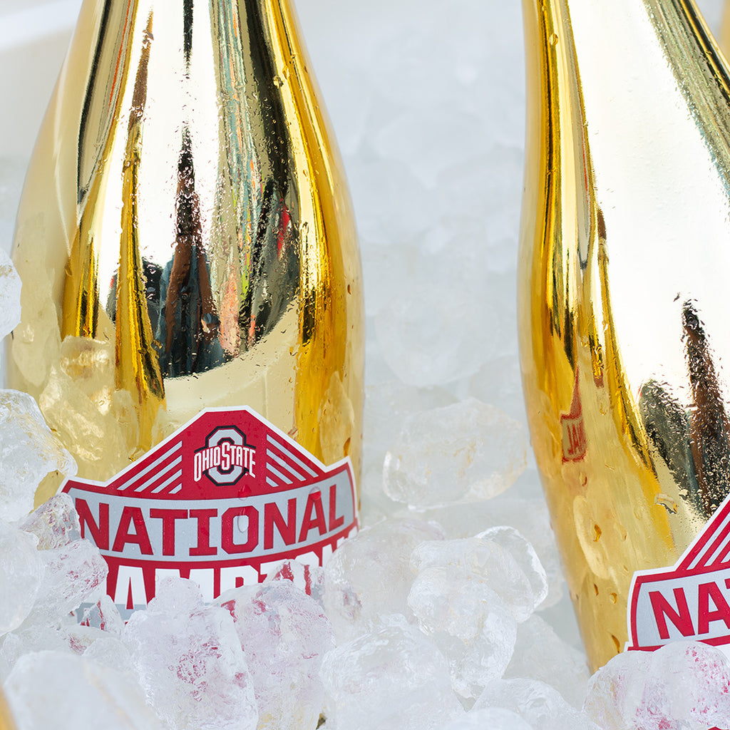 Close up of Ohio State University 2024 National Champions gold metallic bubbly wine bottles in ice