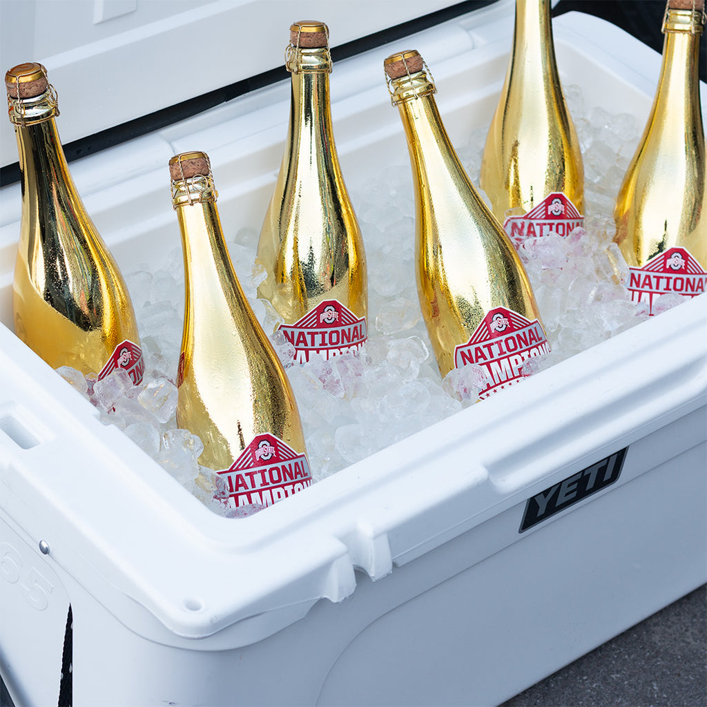 Metallic gold Ohio State University 2024 National Champions bubbly wine bottles in ice in a YETI cooler
