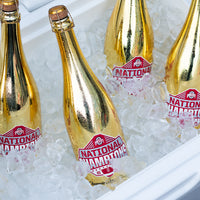 Gold metallic bubbly wine bottles of Ohio State University 2024 National Champions sitting on ice in a cooler