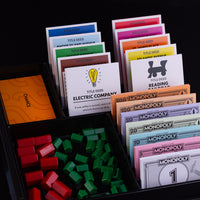 Close up image of Monopoly cards, pieces, and Monopoly money