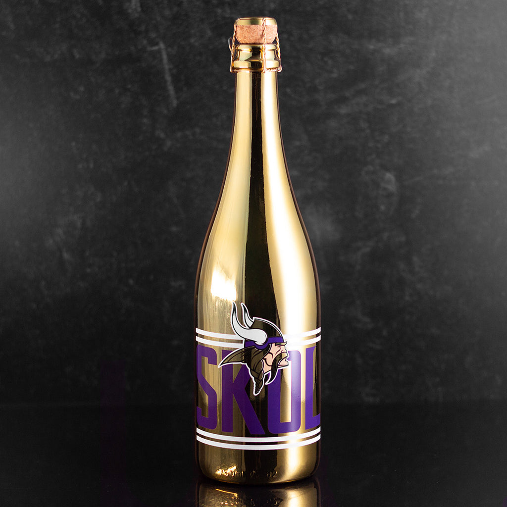 Mano's Wine gold bottle of Blanc de Blanc bubbly wine with Minnesota Vikings logo and purple SKOL text