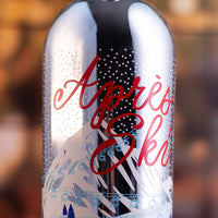 Metallic bottle with 'Apres Ski' text and ski slope design