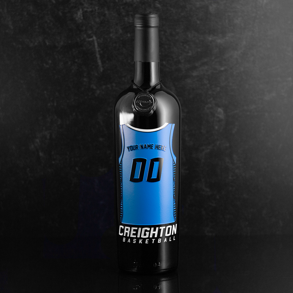 Bottle of wine with a blue Creighton University basketball jersey design on a dark background