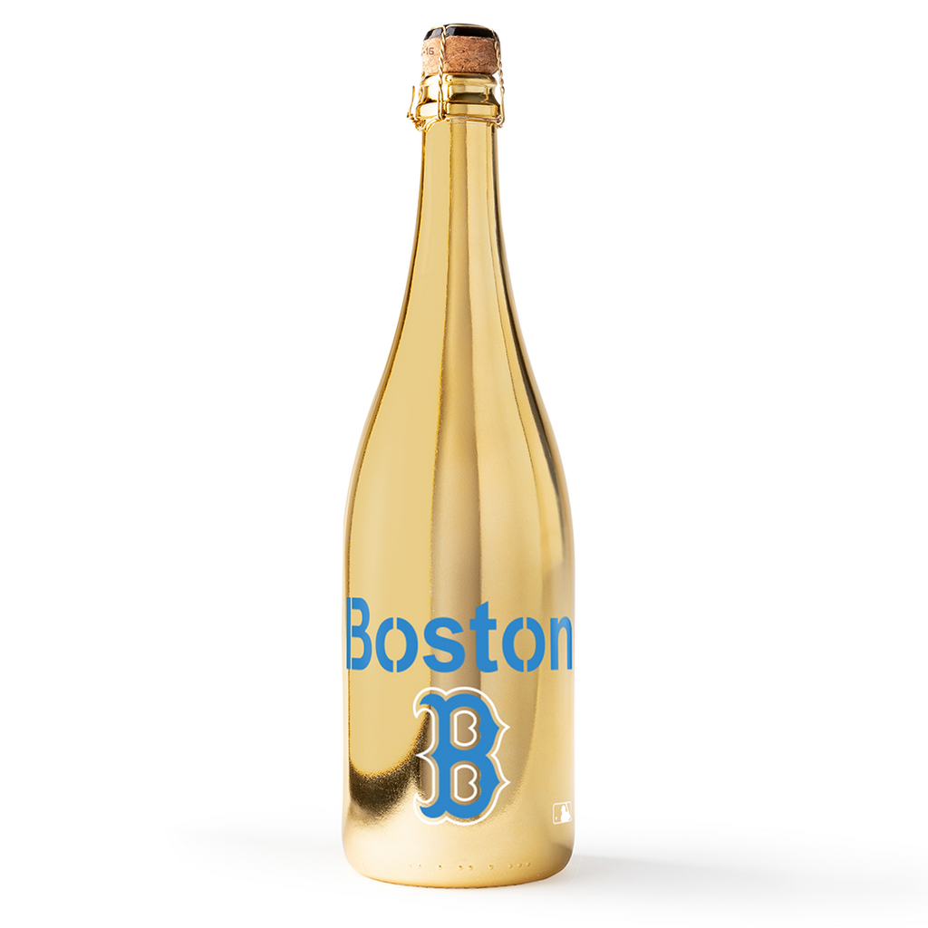 Gold bottle with Boston and MLB City Connect blue B logo on a white background from Mano's Wine