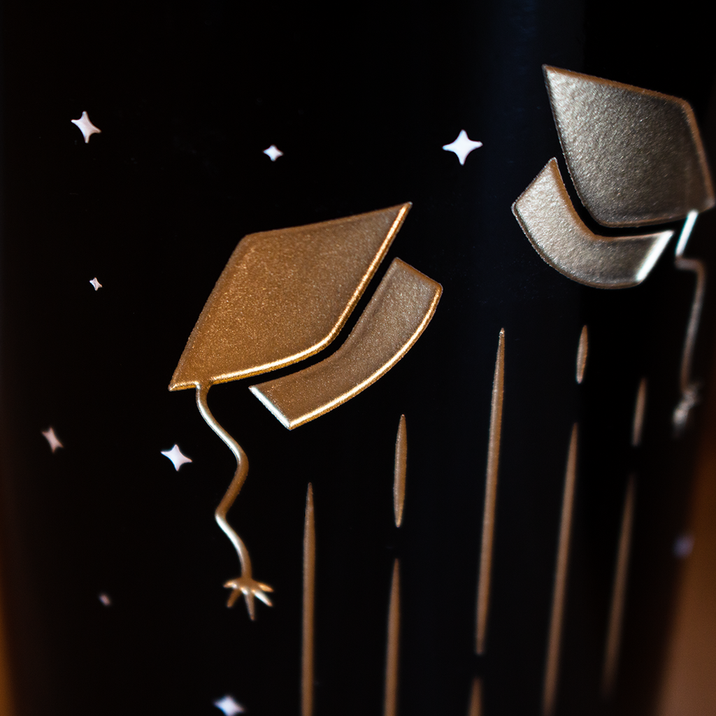 Close up of Custom Graduation Cap Etched Wine etched with stars and graduation caps
